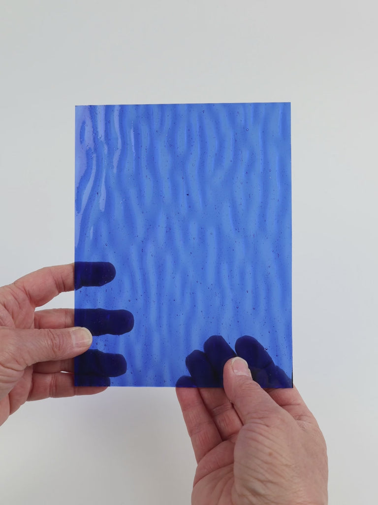 Video of the Blue Gentle Waves glass plate in ripple transparent blue, 15x19cm, held up and tilted to show its pattern and transparency