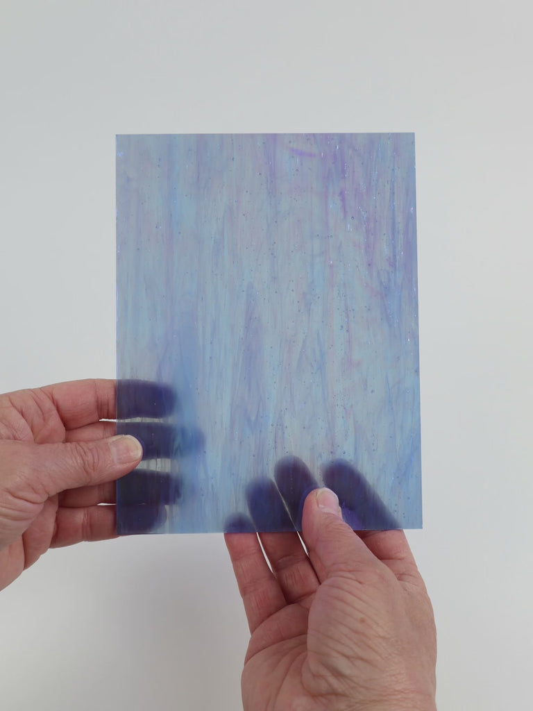 Video of the Marbled Blue Pearl glass plate in iridescent transparent blue, 15x19cm, held up and tilted to show its pattern and transparency