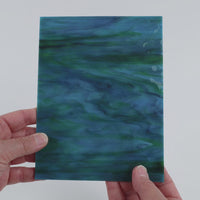 Video of the Peacock Gloss glass plate in ripple translucent teal, 15x19cm, held up and tilted to show its pattern and transparency